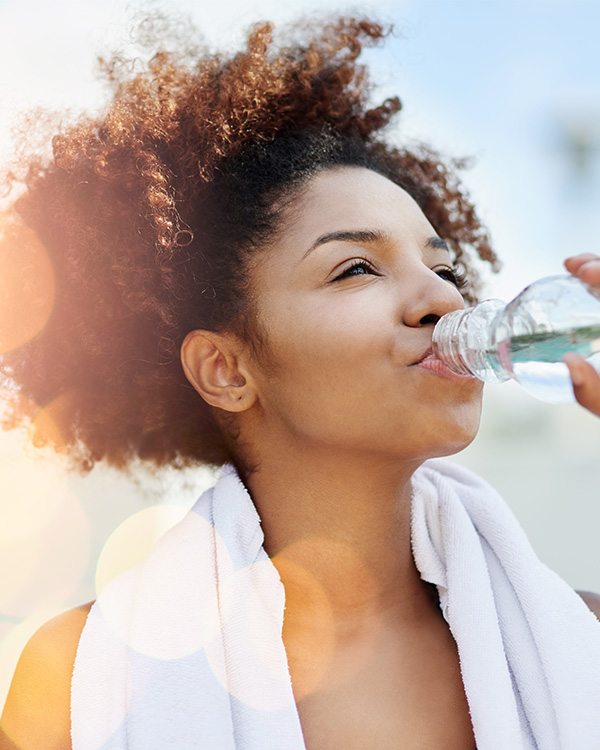 Woman drinking water bottle after excising 