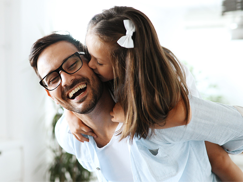 Happy father with daughter on his back smiling